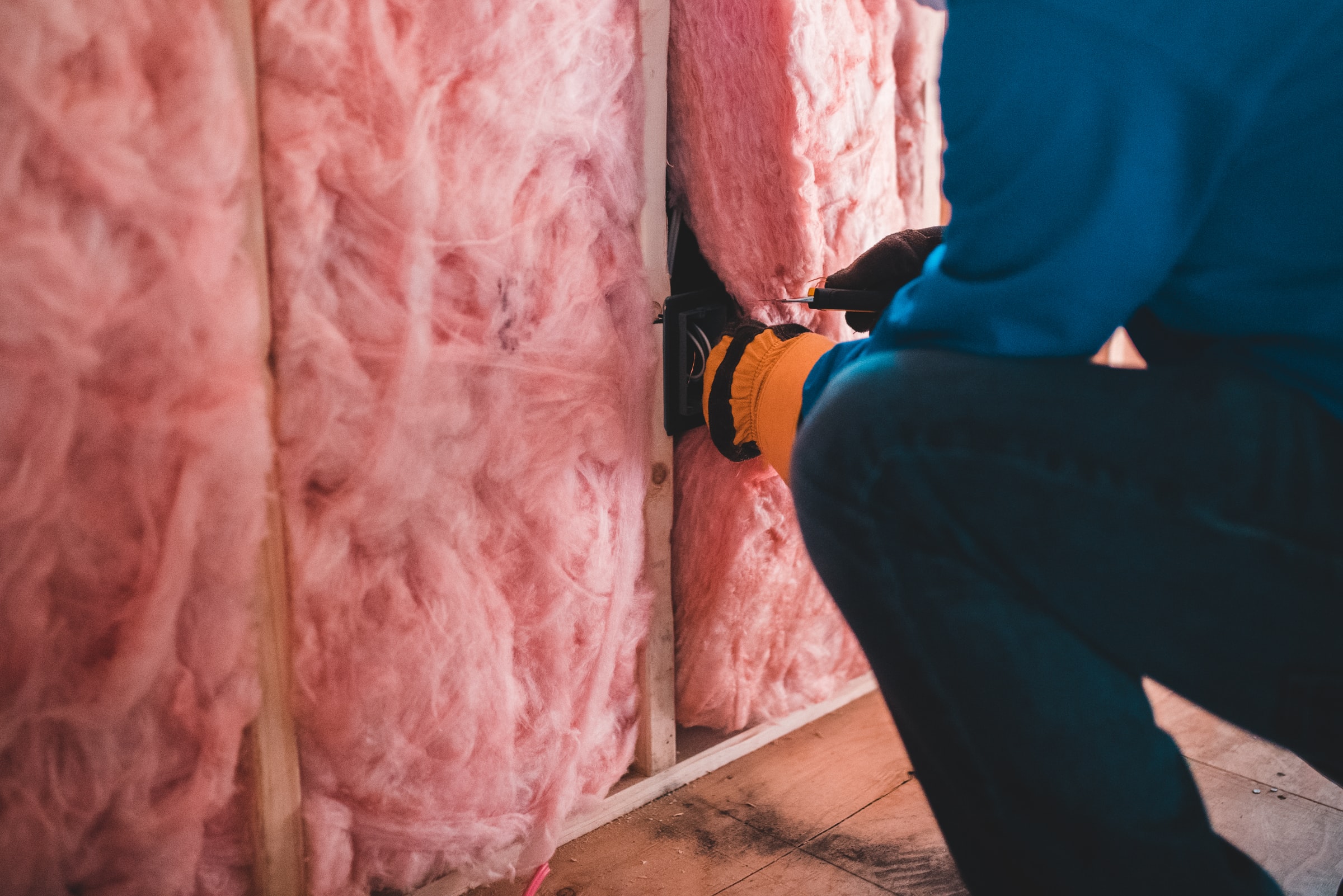 A man installing loft insulation